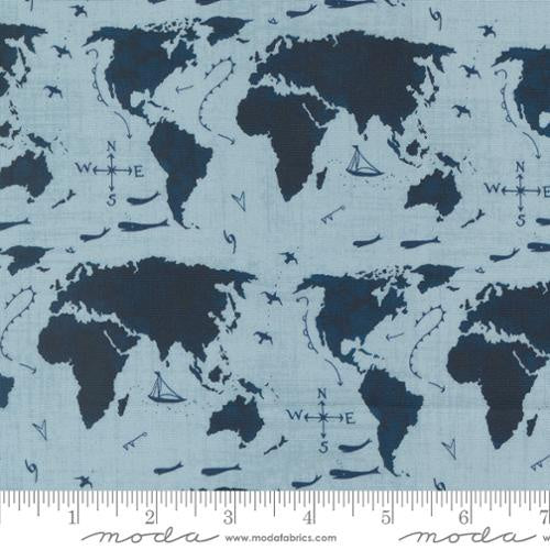  Longshore Seafarers Way Day quilting fabric by Janet Clare. 100% cotton fabric with a world map design featuring sailboats, airplanes, and compass roses in a light blue color. Ideal for coastal-themed projects.